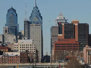 Cover of “Buildings of Pennsylvania: Philadelphia and Eastern Pennsylvania” featuring a view of the Philadelphia skyline with the Liberty Place towers, high-rise buildings, a river in front, and several docked boats along the waterfront.
