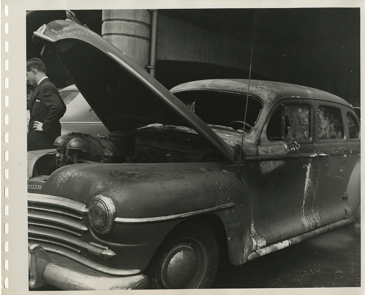 A damaged car shows the aftermath of the explosion’s impact on vehicles parked on the Mon wharf, 1947. | Heinz History Center