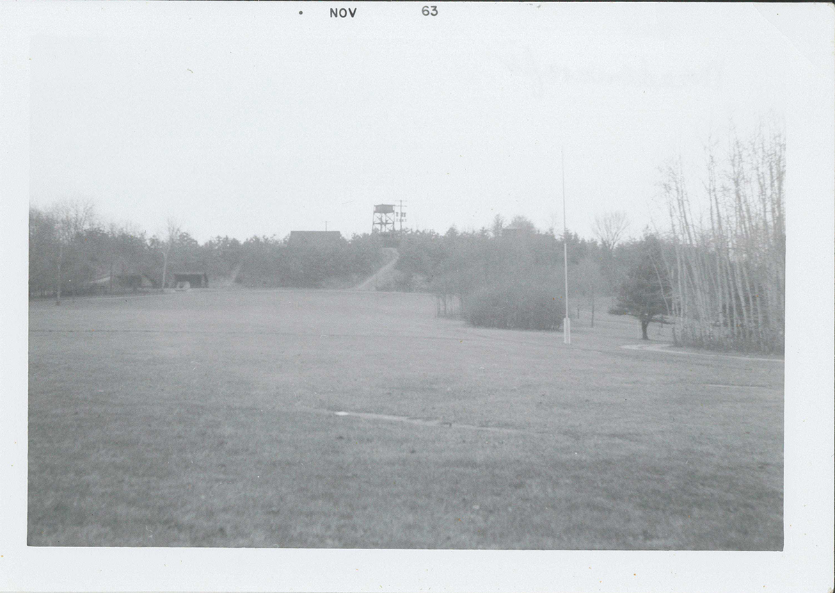 This photograph was taken from a similar vantage point of the back door of the Visitor Center today. If you were to pass between the flag pole and grove of aspen trees on the right, you'd be going to the frontier today. At the left of the frame, where the Adirondack shelters are, is where the Miller Museum is currently located.