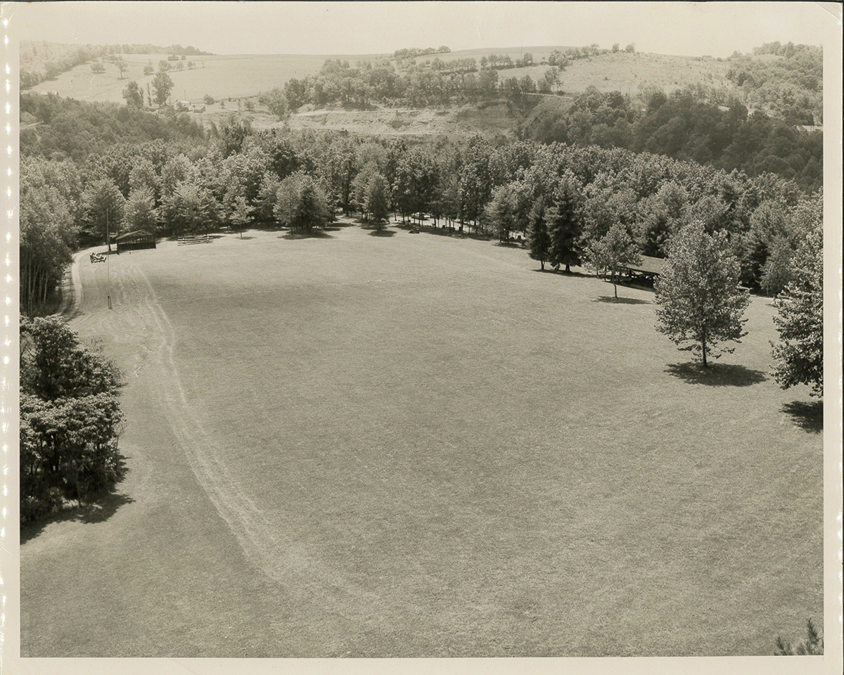 This photograph was taken from the top of the Green towards where the Visitor Center is today. The softball diamond can be seen on the left. The parking lot and camping area at the bottom of the green and the pavilion, which stands today, on the right.