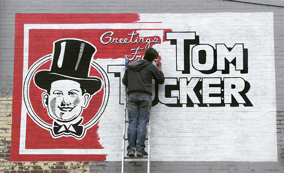 A new Tom Tucker wall sign was painted in 2012 by muralist Anthony Purcell on the side of Comet News in Braddock. He’s painted and restored dozens of wall signs throughout the city. Courtesy of Anthony Purcell.