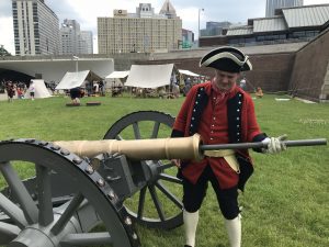 Costumed 18th century reenactor loads a cannon at the Fort Pitt Museum.