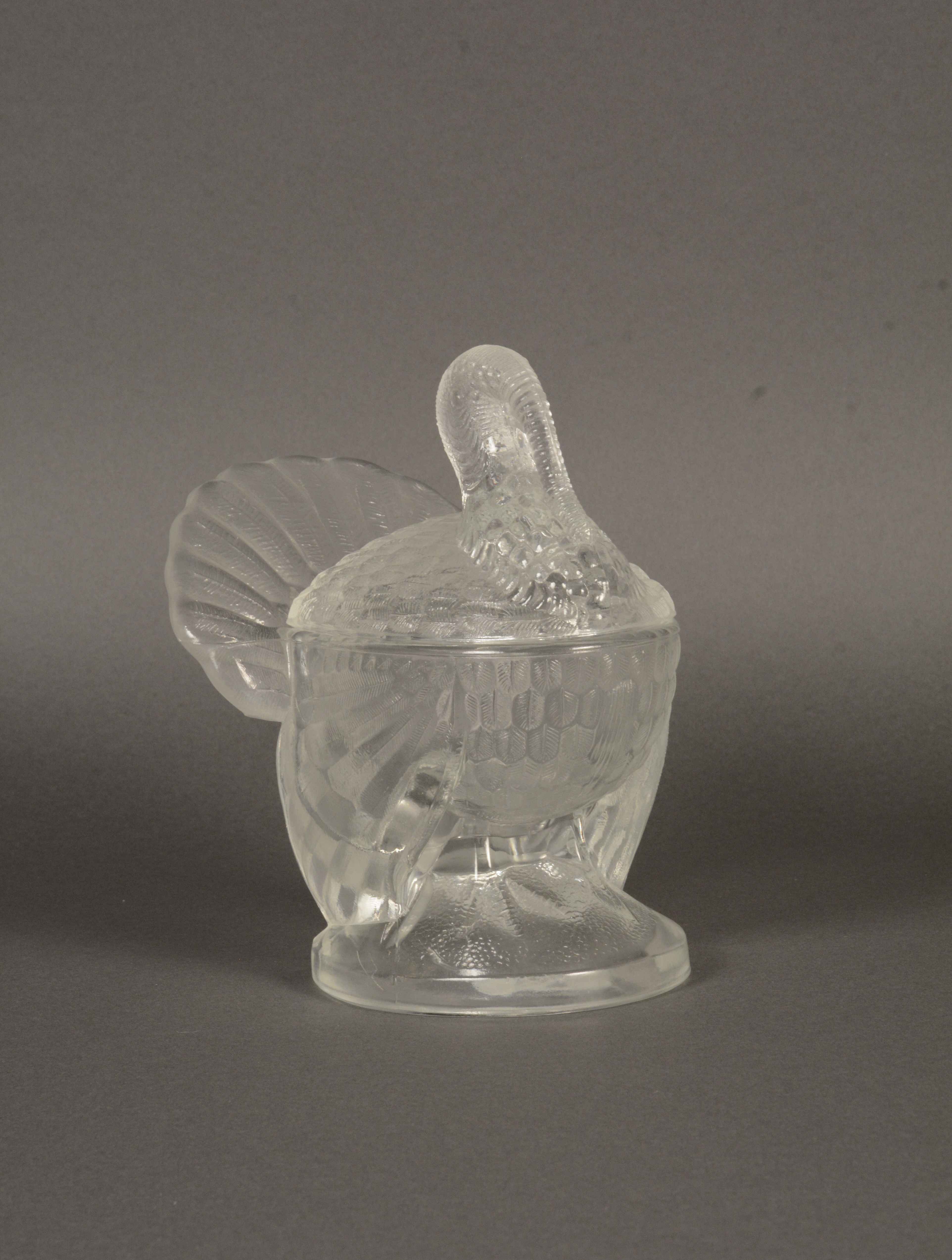 L.E. Smith Glass Company produced the first glass turkeys in 1943. Capable of holding soup, candy, or even cranberry sauce, this glass bird is an excellent table decoration for the holidays. Gift of L.E. Smith Glass Company.