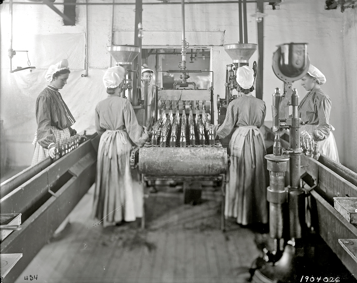 Employees fill bottles in the ketchup bottling department, 1904.