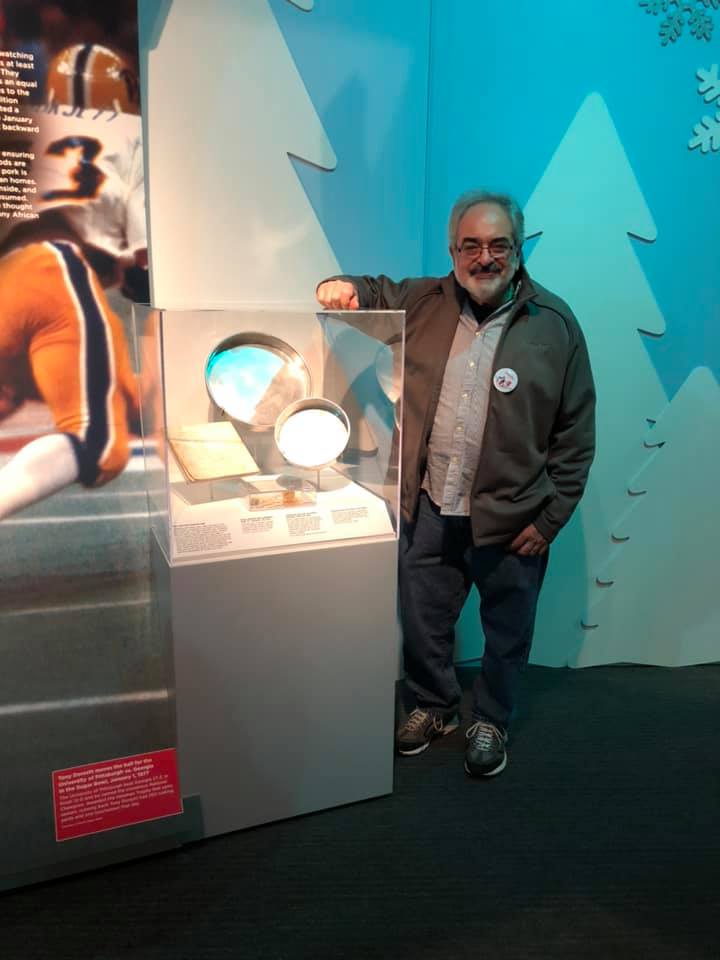 Gus Karafilis alongside his mother’s home artifacts at the opening of A Very Merry Pittsburgh on Nov. 16, 2019.