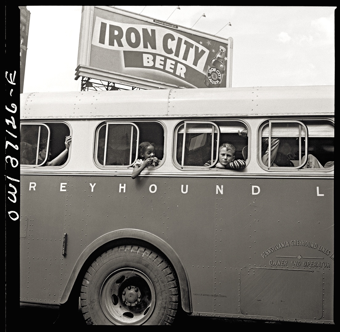 A billboard for Iron City Beer towers over a bus as it departs Pittsburgh’s Greyhound terminal, 1943.