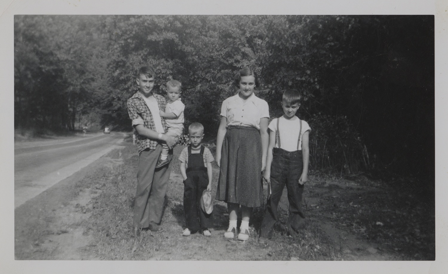 Paul posing with his siblings in the summer of 1954 alongside a road. Left to right: Paul, Alan, Glen, Mary Ellen, and George Dick. Holly and Paul Dick Family Papers and Photographs, MSS 1177, Detre Library & Archives at the History Center.
