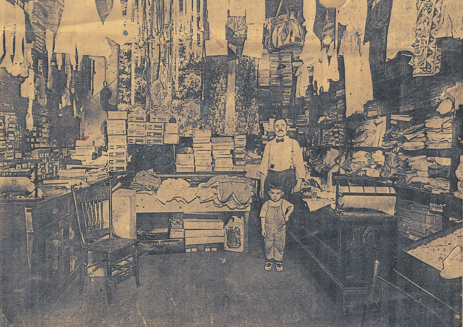 Sam Reznik and his son Milton Reznik, better known as “Motty,” standing inside Sam Reznik & Sons dry goods store on Logan Street. Like many dry goods businesses of the day, the store displayed its entire inventory. “They thought if people didn’t see everything they had, they wouldn’t know that they had it,” his granddaughter Rochelle Blumenfeld recalled. “So nothing was hidden.” Courtesy of Rochelle Blumenfeld.