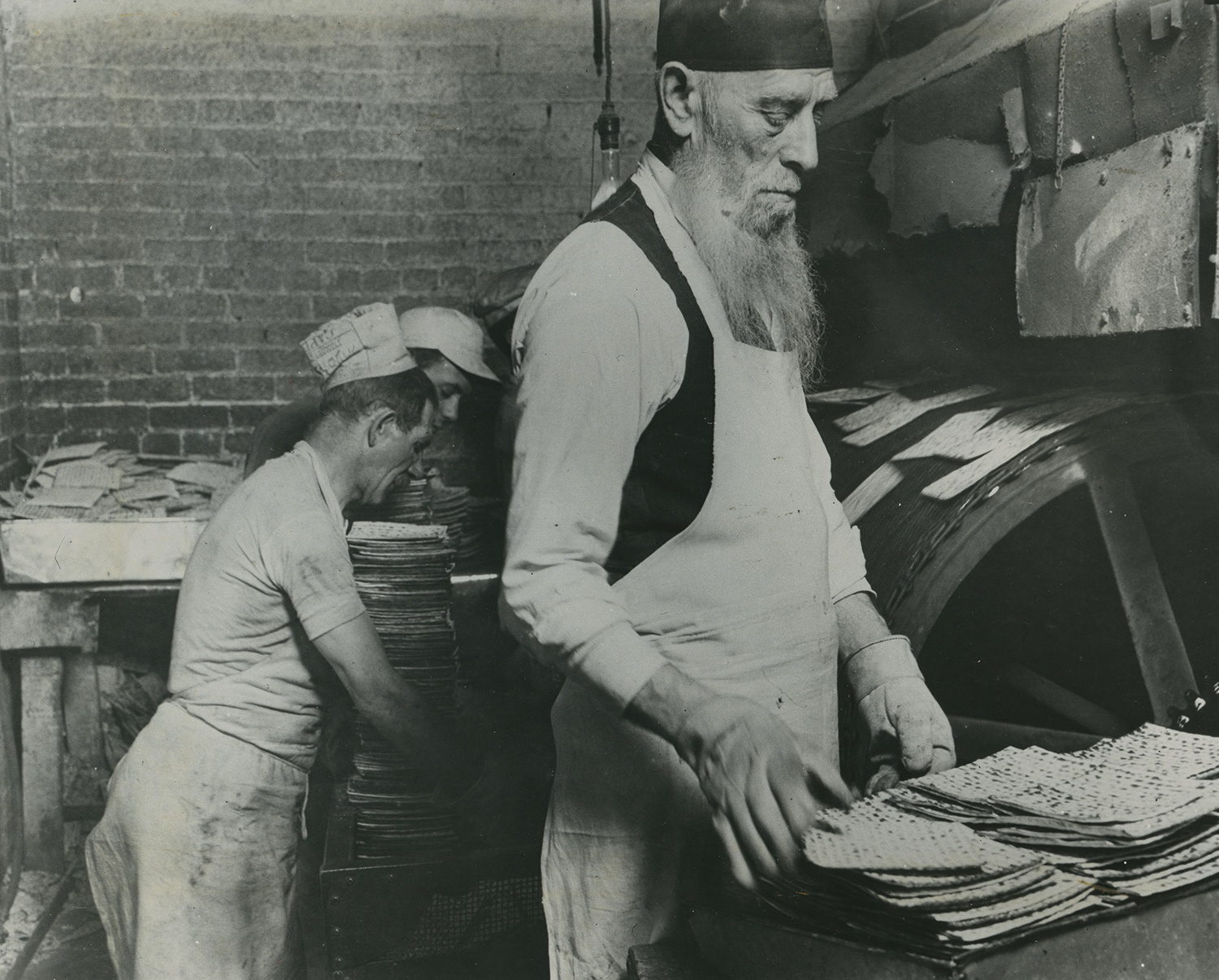 Jacob Radbord inspecting matzah at the Caplan Baking Company factory on Legan Street in the Hill District, 1934.