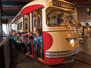 Children playing on the trolley in the Great Hall of the Heinz History Center.