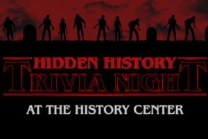 Silhouettes of zombies and gravestones under a red sky. Text: Hidden History Trivia Night at the History Center in bold letters. *AI generated alt text