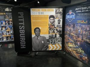 Three museum panels on Pittsburgh football feature the NFL draft, HBCU to NFL pipeline, and Western PA players with vintage photos. *AI generated alt text