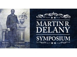 Sepia-toned photo of Martin R. Delany by a pedestal with a plant; text reads Martin R. Delany Symposium on blue background. *AI generated alt text