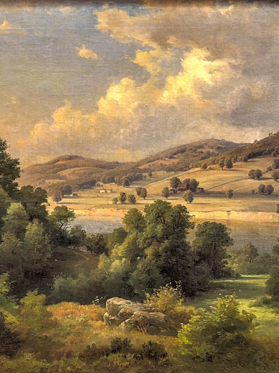 A landscape showing green trees, rolling hills, and a sky with scattered clouds illuminated by sunlight. Fields and distant mountains are visible in the background. The composition represents the natural environment historically found near Fort Pitt. *AI generated alt text