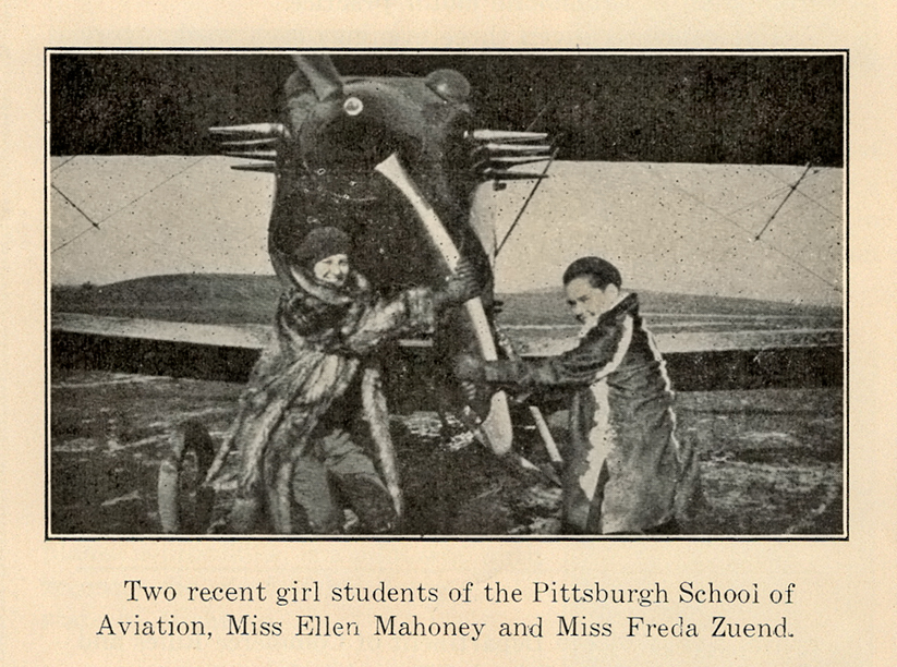 Two women in coats stand beside a vintage propeller airplane, each holding the propeller. They are identified in the caption as Miss Ellen Mahoney and Miss Freda Zuend, students of the Pittsburgh School of Aviation. *AI generated alt text