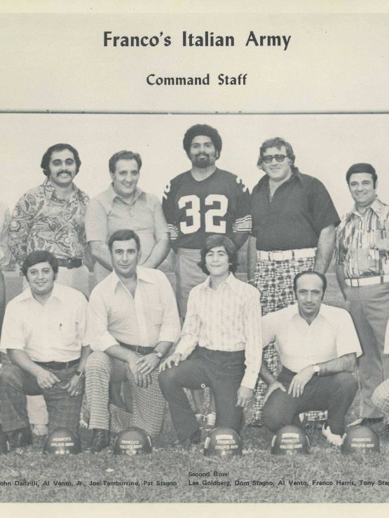 A black-and-white photograph showing 14 men posed beneath a sign reading “Francos Italian Army Command Staff.” Most of the men are standing, with a few kneeling in front. One man in the back row is wearing a football jersey with the number 32. *AI generated alt text